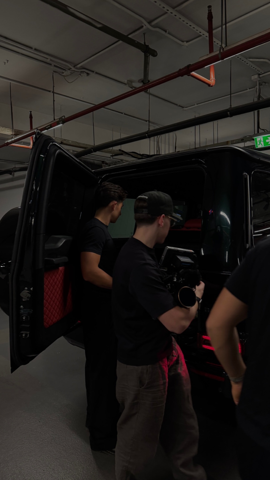 Members stepping out beside a luxury vehicle